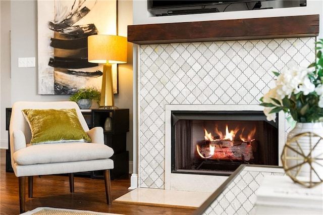 living area featuring wood finished floors and a tiled fireplace