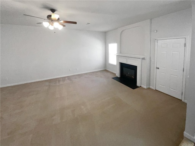 unfurnished living room with a fireplace with flush hearth, light colored carpet, a ceiling fan, and baseboards