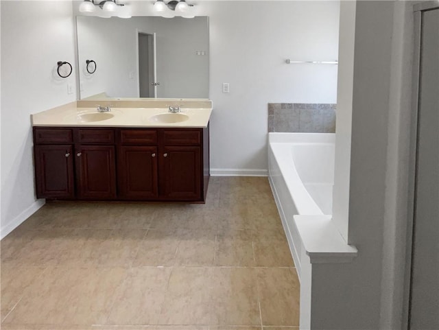 full bath with a sink, baseboards, a garden tub, and double vanity