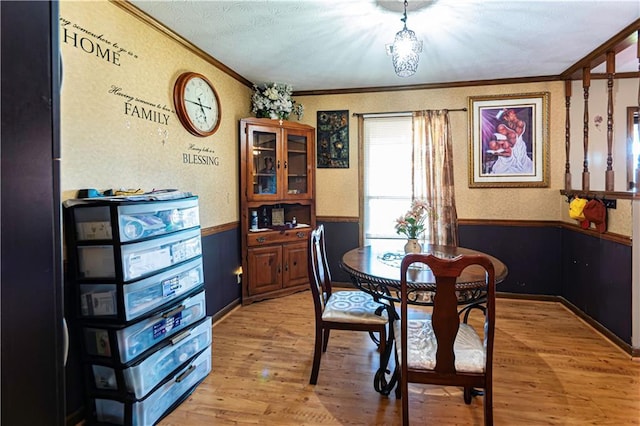 dining space featuring light wood-type flooring and crown molding