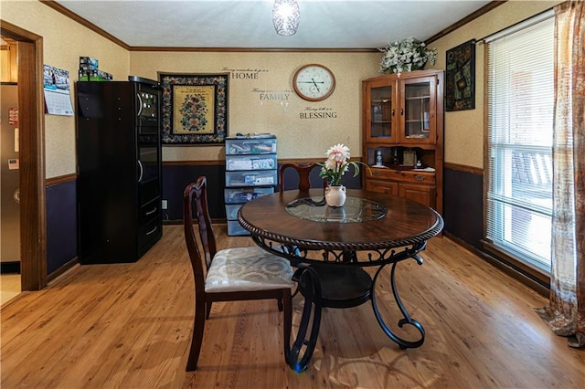 dining space featuring crown molding and light hardwood / wood-style flooring