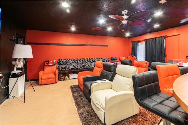 carpeted home theater room with ceiling fan