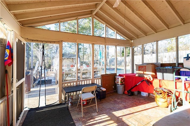 sunroom / solarium featuring vaulted ceiling with beams and a healthy amount of sunlight