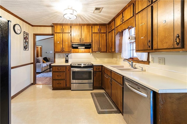 kitchen featuring sink, ornamental molding, a textured ceiling, and appliances with stainless steel finishes