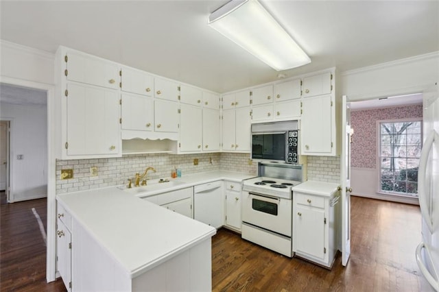 kitchen with white appliances, dark hardwood / wood-style floors, sink, and white cabinets