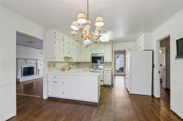 kitchen featuring white cabinetry, range, hanging light fixtures, and white fridge