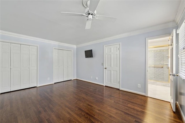 unfurnished bedroom with dark hardwood / wood-style flooring, ensuite bath, ornamental molding, and multiple closets