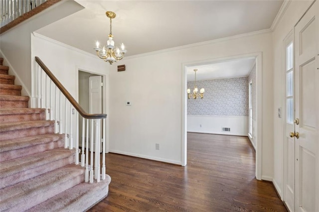 foyer entrance with dark hardwood / wood-style flooring, a notable chandelier, and crown molding