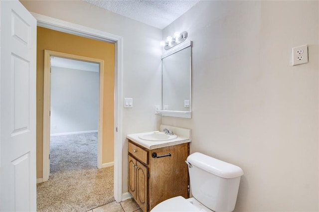 bathroom with toilet, vanity, and a textured ceiling