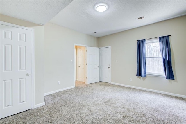 unfurnished bedroom featuring carpet floors and a textured ceiling