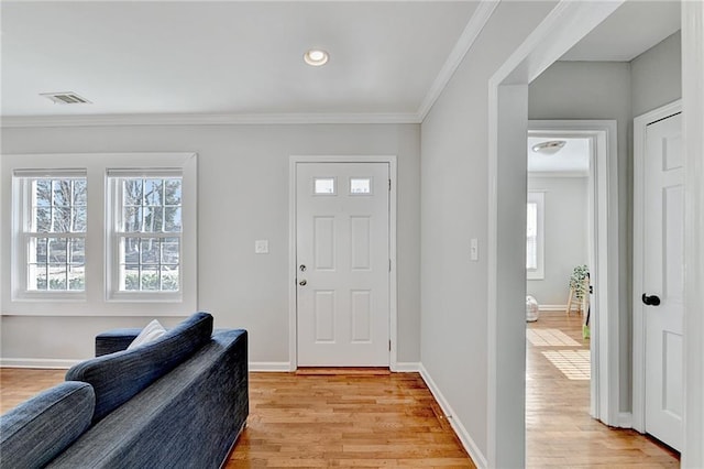 entrance foyer with light hardwood / wood-style flooring and crown molding