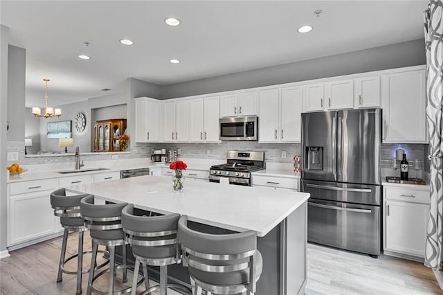 11352 Musette Cir, Alpharetta, GA 30009 - kitchen featuring stainless steel appliances, tasteful backsplash, a kitchen island, white cabinetry, and recessed lighting