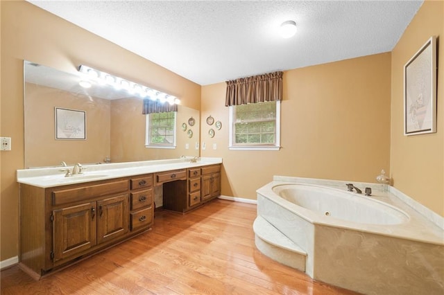 3436 Laurelwood Ct NE, Roswell, GA 30075 - bathroom featuring a bath, double vanity, wood finished floors, and a textured ceiling