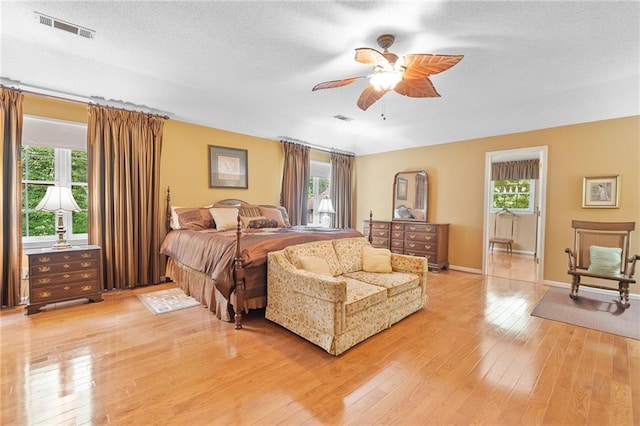 3436 Laurelwood Ct NE, Roswell, GA 30075 - bedroom with multiple windows, light wood finished floors, a textured ceiling, and ceiling fan