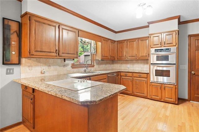 3436 Laurelwood Ct NE, Roswell, GA 30075 - kitchen with appliances with stainless steel finishes, brown cabinetry, a peninsula, light wood-type flooring, and ornamental molding