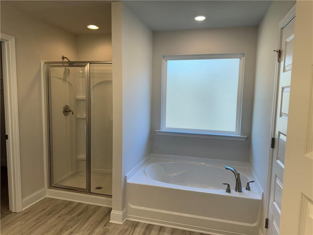 bathroom with shower with separate bathtub and hardwood / wood-style flooring