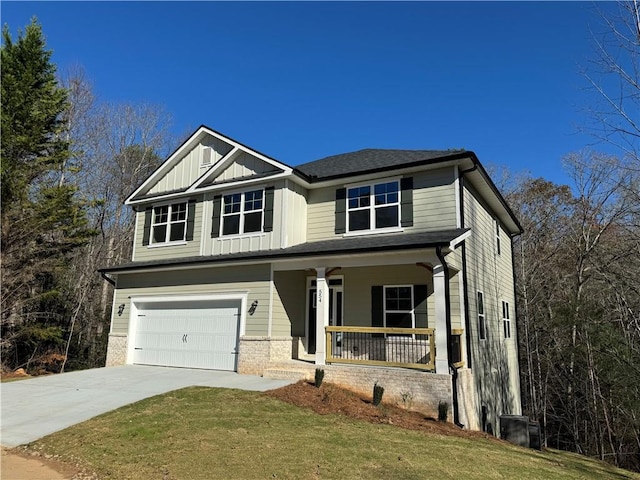 craftsman house featuring a front yard, a porch, and a garage