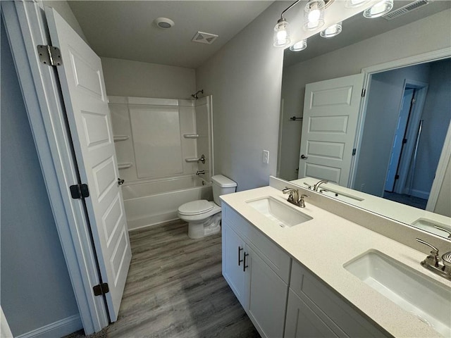 full bathroom with hardwood / wood-style floors, vanity, toilet, and shower / washtub combination