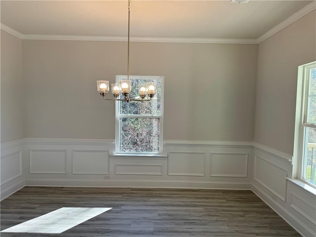 unfurnished dining area with a notable chandelier, dark hardwood / wood-style flooring, and crown molding