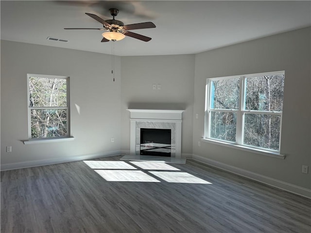 unfurnished living room with ceiling fan, dark hardwood / wood-style flooring, and a fireplace