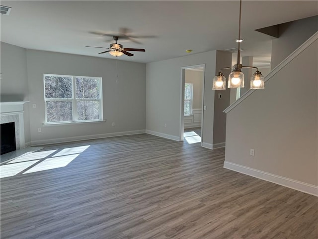 unfurnished living room with hardwood / wood-style floors, ceiling fan, and a premium fireplace