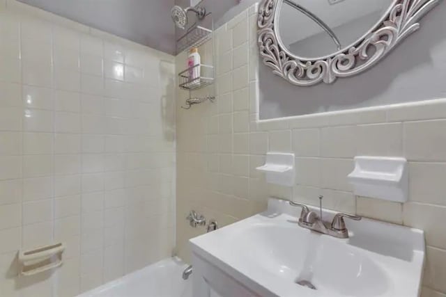 full bathroom with tub / shower combination, tile walls, and a sink