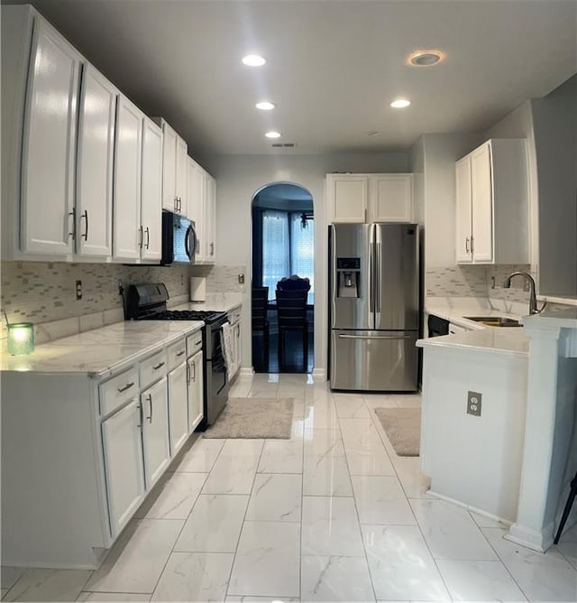 kitchen with white cabinets, sink, stainless steel refrigerator with ice dispenser, and black / electric stove