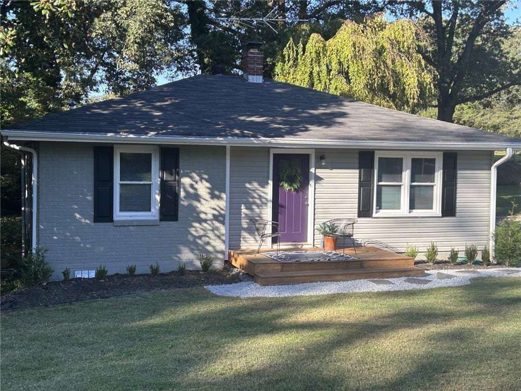 ranch-style home featuring a front yard and a deck