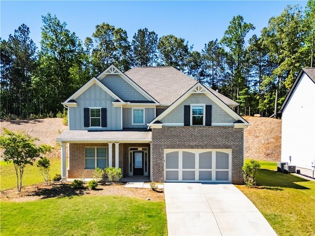 craftsman-style house featuring an attached garage, concrete driveway, board and batten siding, a front lawn, and a porch