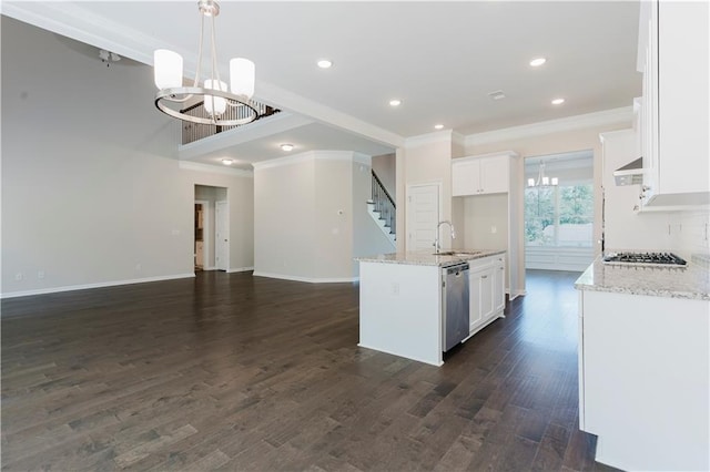 kitchen with a notable chandelier, a sink, open floor plan, crown molding, and stainless steel appliances