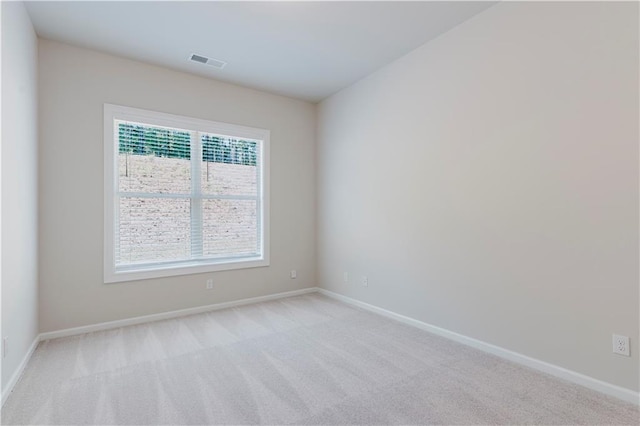empty room with visible vents, baseboards, and light carpet
