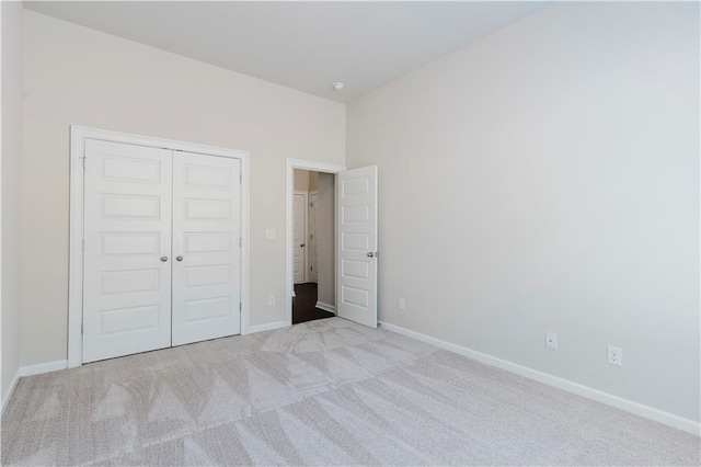 unfurnished bedroom featuring carpet flooring, a closet, and baseboards