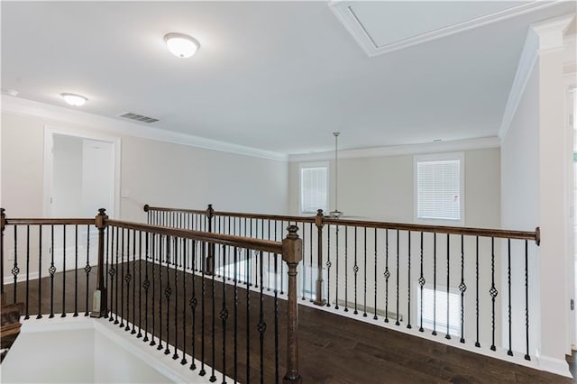 hallway with ornamental molding, an upstairs landing, visible vents, and wood finished floors