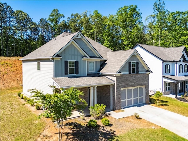 view of front facade with a front yard, board and batten siding, driveway, and a garage
