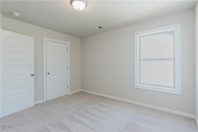 unfurnished bedroom featuring light colored carpet and baseboards