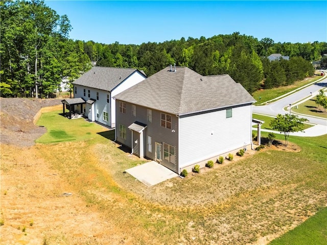 view of side of property with a yard and roof with shingles