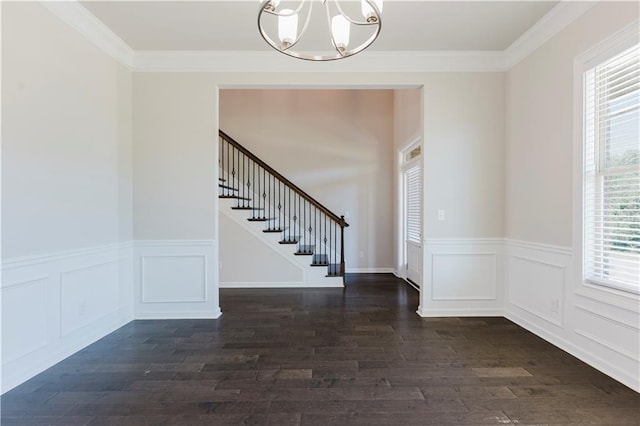 foyer entrance with stairway, a chandelier, wainscoting, and dark wood-type flooring