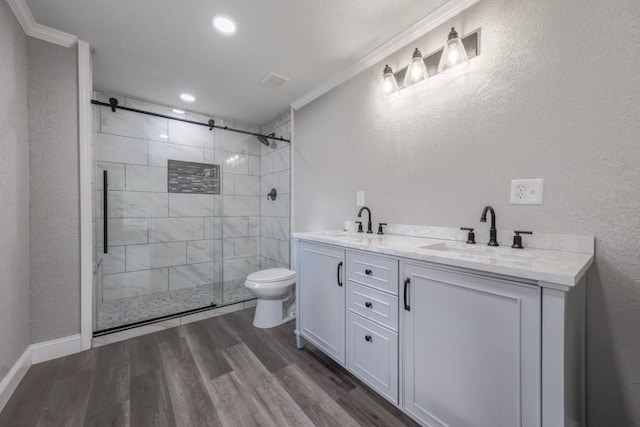 full bathroom featuring crown molding, toilet, a shower stall, wood finished floors, and a textured wall