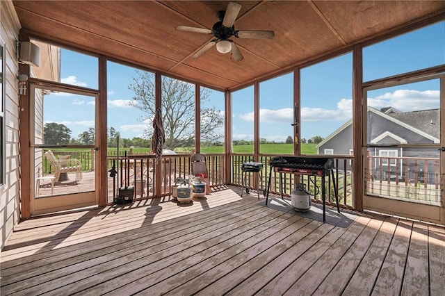 sunroom / solarium featuring a ceiling fan
