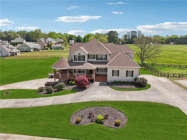view of front facade with a chimney, fence, curved driveway, a front lawn, and roof with shingles