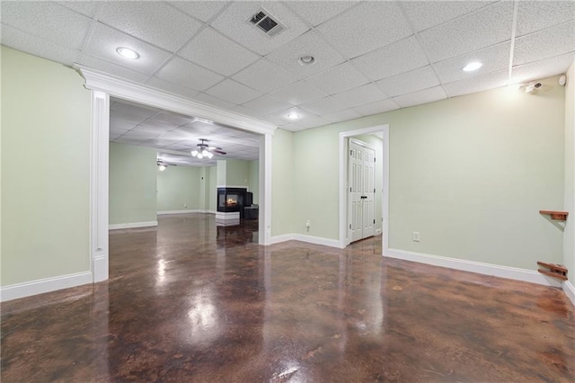 unfurnished living room featuring concrete floors, a drop ceiling, visible vents, recessed lighting, and baseboards
