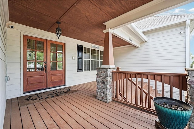wooden deck featuring a porch and french doors