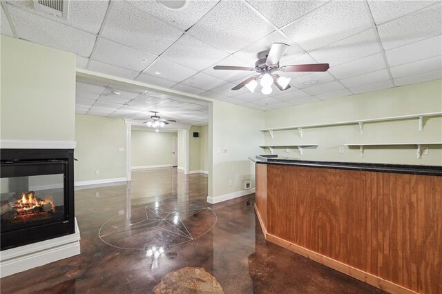 bar featuring concrete flooring, visible vents, a ceiling fan, and a paneled ceiling