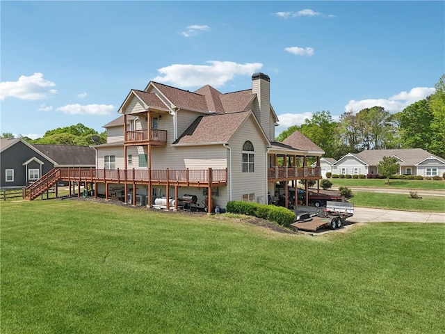 rear view of property with a yard, a balcony, a chimney, a shingled roof, and stairs