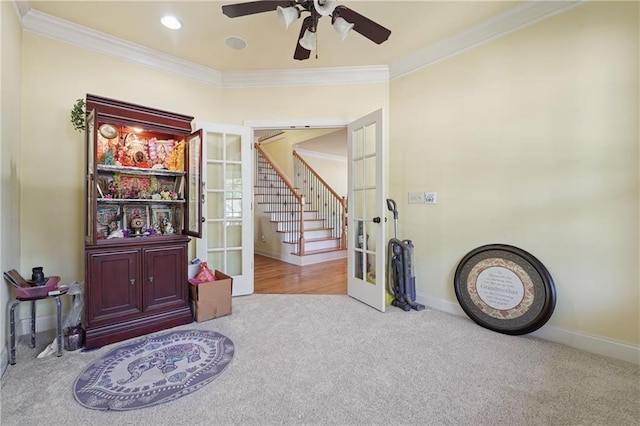 interior space featuring baseboards, carpet flooring, french doors, a ceiling fan, and crown molding