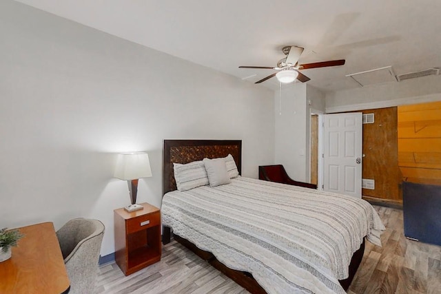 bedroom with a ceiling fan, attic access, visible vents, and light wood-style floors