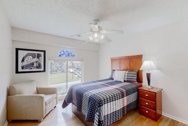 bedroom featuring a ceiling fan, light wood-style flooring, and baseboards