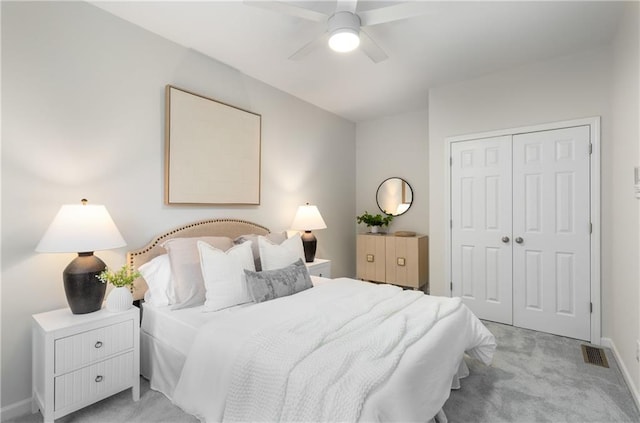 bedroom featuring light carpet, baseboards, visible vents, ceiling fan, and a closet