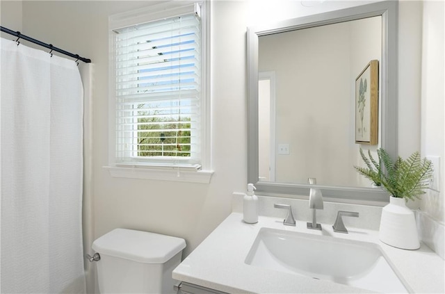 bathroom featuring toilet, curtained shower, and vanity