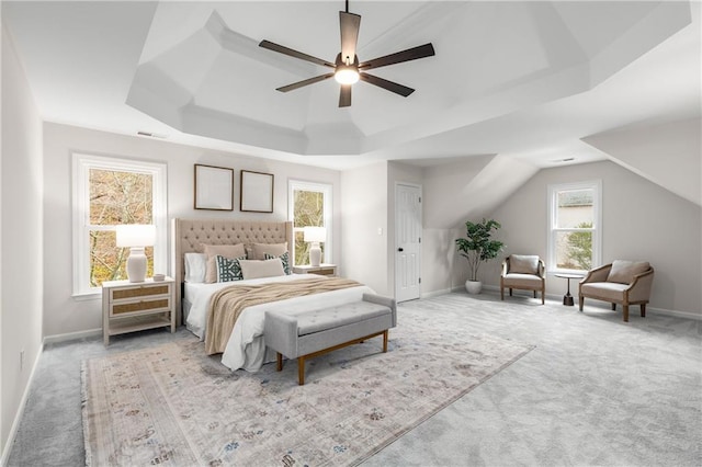 bedroom featuring carpet floors, a tray ceiling, baseboards, and a ceiling fan